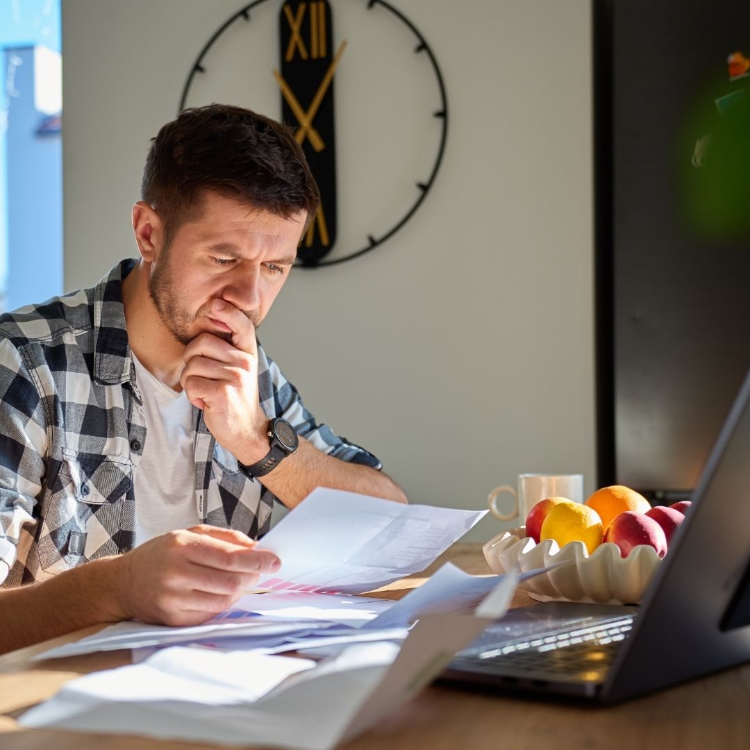 Executor Complete Probate Without a Solicitor Executor completing probate paperwork at home using financial documents and a laptop.